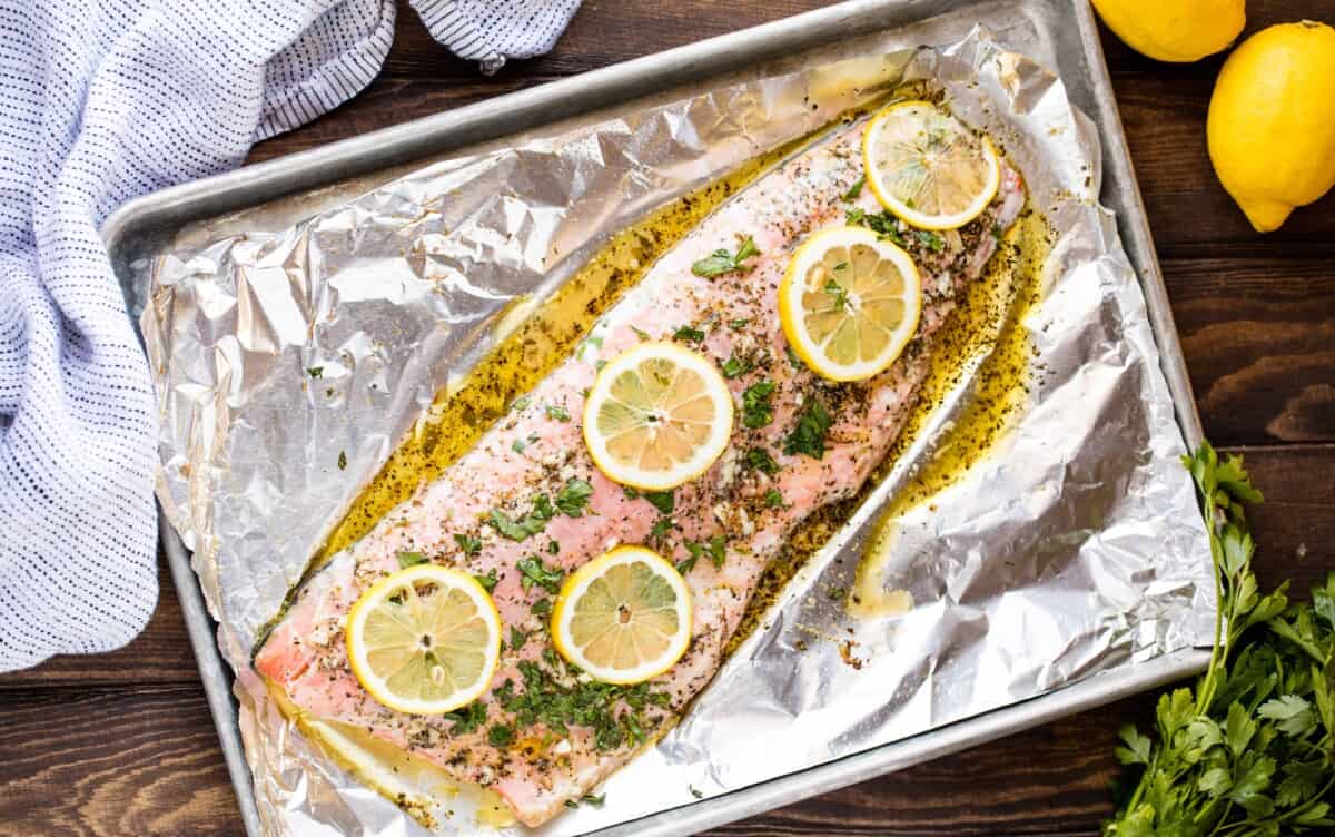 Birrd's eye view of baked garlic herb salmon on a baking sheet.
