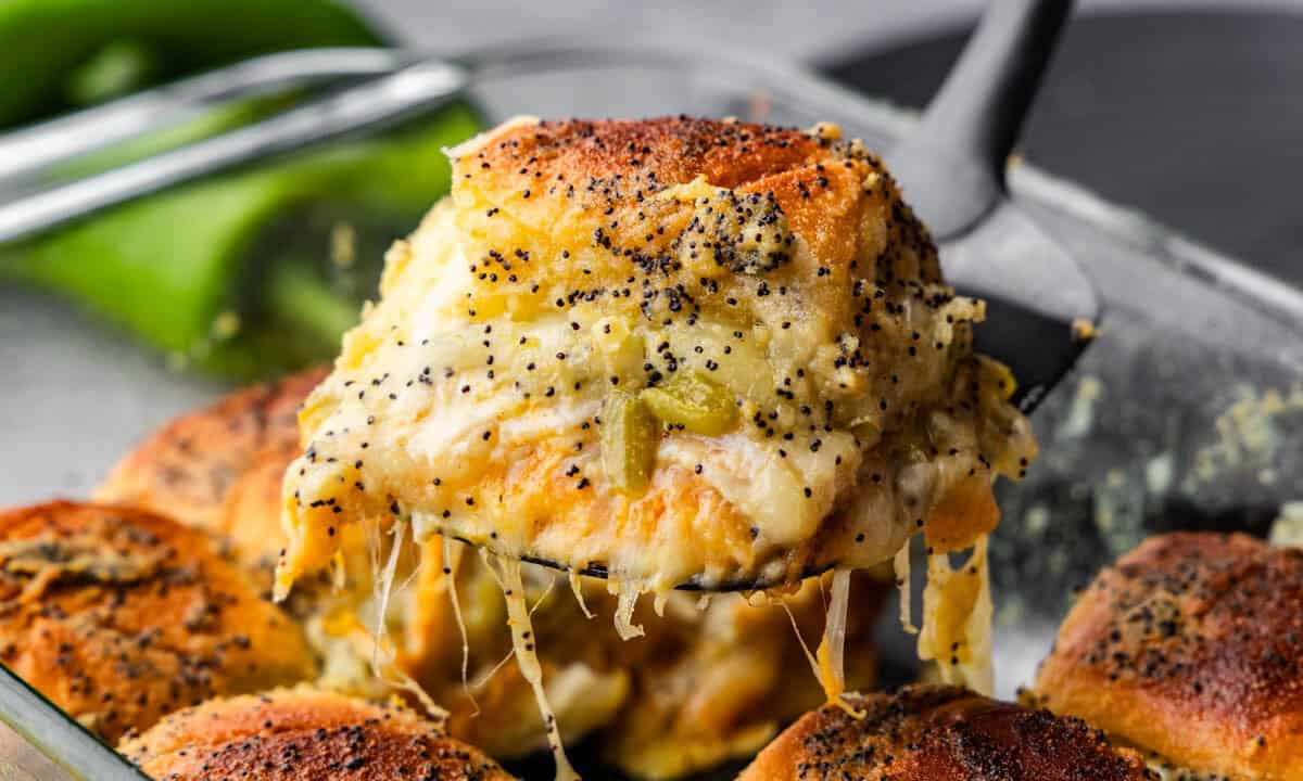 A southwest turkey slider on a hawaiian roll being lifted out of the pan.